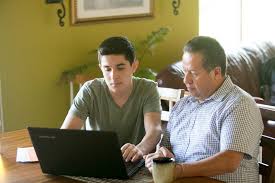 student looking at computer with parent